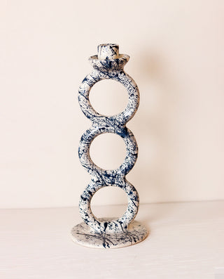 Decorative candle holder with circular design on a white background
