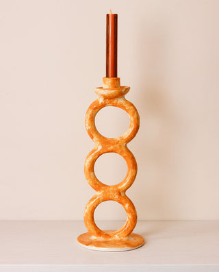 Decorative candle holder with circular design on a plain background