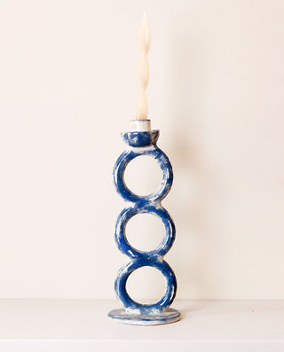 blue ceramic candle holder with three rings in a white background