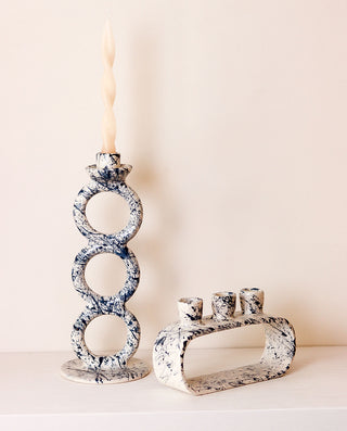 Decorative candle holders with marble-like pattern on a neutral background