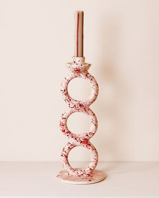 Decorative candle holder with purple and white pattern on a plain background