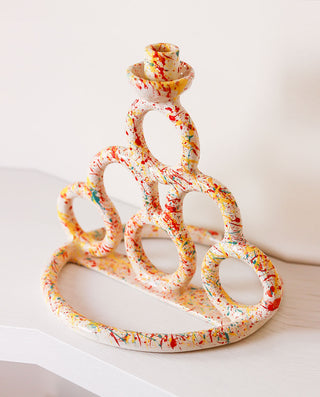 Decorative candle holder with colorful design on a white surface
