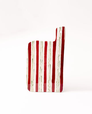 Red and white striped ceramic serving board on a white background