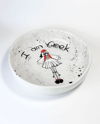 White ceramic HANDCRAFTED BOWL with black speckles featuring a GREEK FOLK character and text on a white background