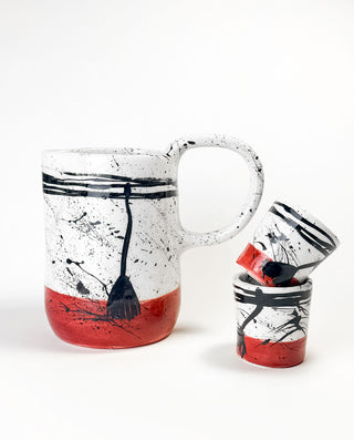 Greek Ceramic pitcher and cup with black and red abstract design on a white background