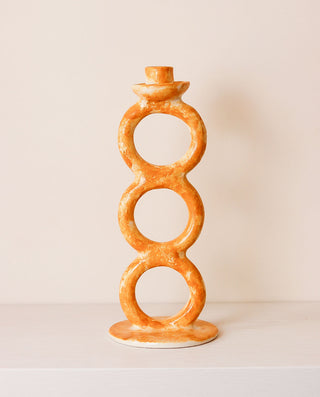 Decorative candle holder with circular design on a plain background