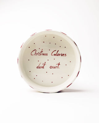 White ceramic plate with red text 'Christmas calories don't count' on a white background