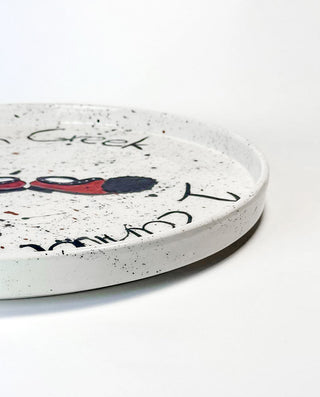 Round ceramic plate with Greek inspired   modern hand paint  on a white background