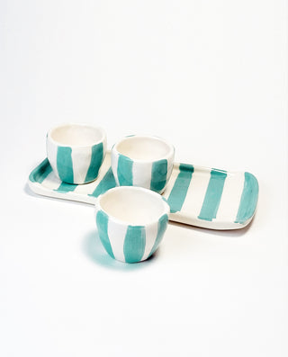 A set of three white espresso cups with blue stripes, accompanied by a matching blue and white striped plate.