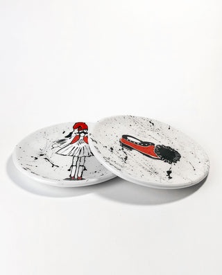 Two round ceramic coasters with artistic greek designs on a white background