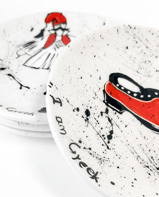 Speckled ceramic plates with Greek-themed designs on a white background