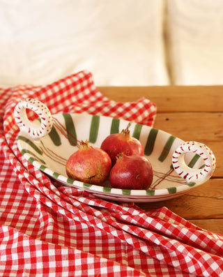 Pomegranates on a decorative ceramic plate with a red and white checkered cloth