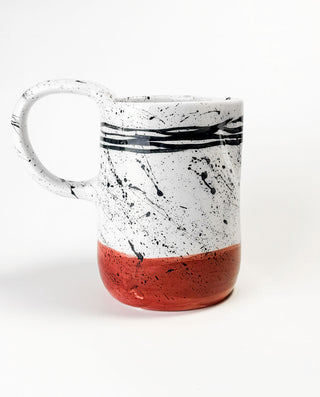 Greek Ceramic carafe with black splash design and red base on a white background