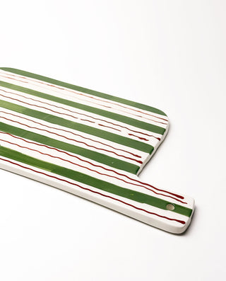 Rectangular ceramic cutting board with green and red stripes on a white background