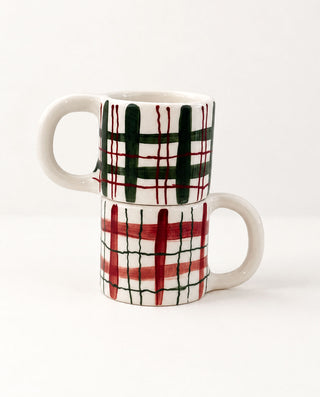 Set of two handmade ceramic mugs featuring complementary burgundy and forest green plaid patterns.