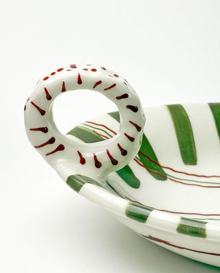 Ceramic platter with green and red patterns on a white background