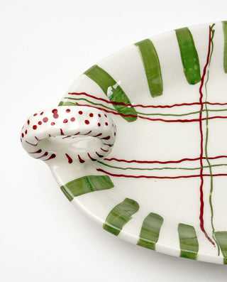 Ceramic christmas dish with green and red striped pattern on a white background