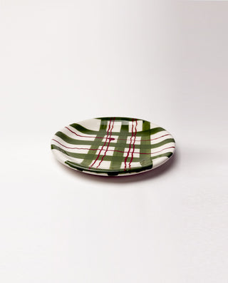 Small ceramic plate with green and red plaid pattern on a white background