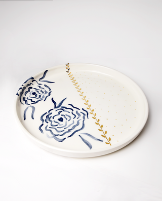 A ceramic serving platter with a royal blue floral pattern and gold accents on the edges.
