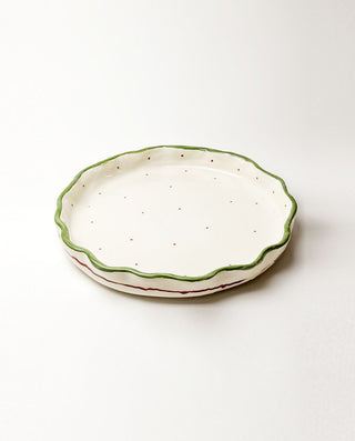 Ceramic dish with green rim on a white background
