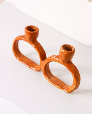 Ceramic candle holder with two small cups on a white background