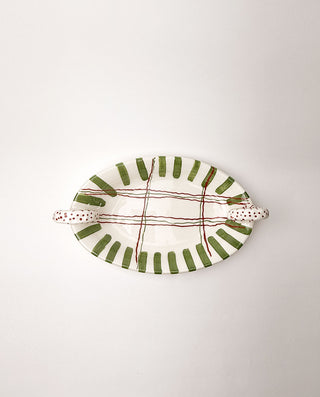 Ceramic platter with green and red patterns on a white background