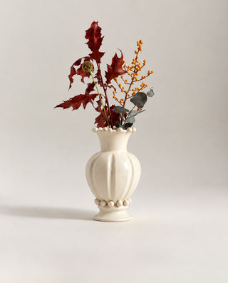 Macro view of the Pearl handmade ceramic vase highlighting its soft matte white glaze, curved neck and pearl-like details filled with flowers