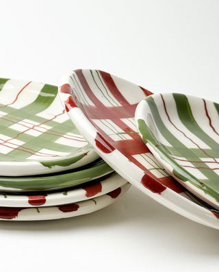 Set of ceramic plates with red, green, and white patterns on a white background