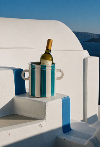 Bottle of wine in a blue and white striped cooler on a Greek island stairs
